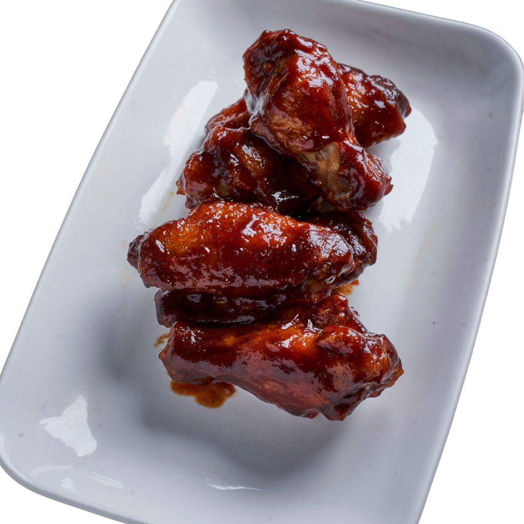 A plate containing several BBQ wings, with a white background.