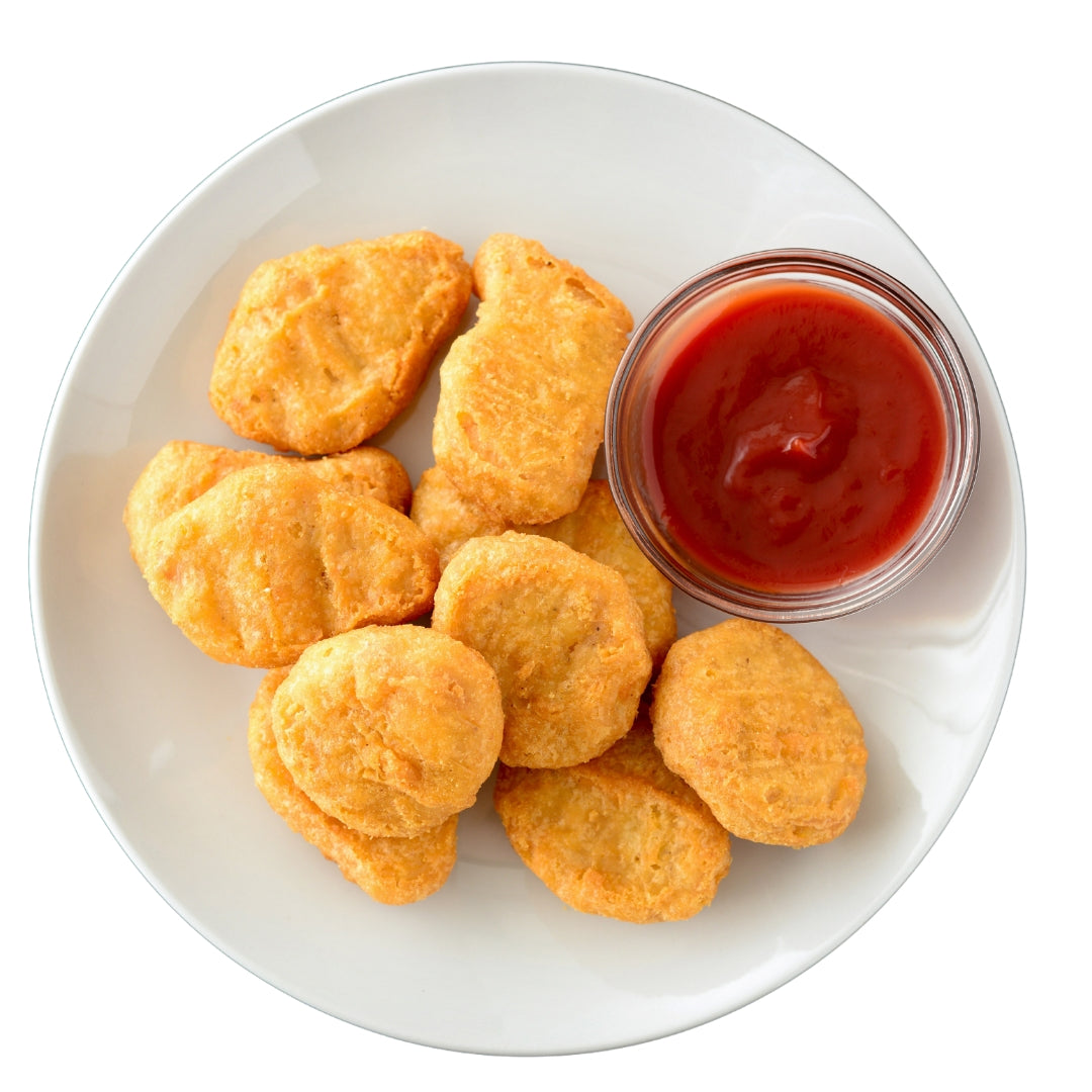 A plate of chicken nuggets next to a ketchup bottle.